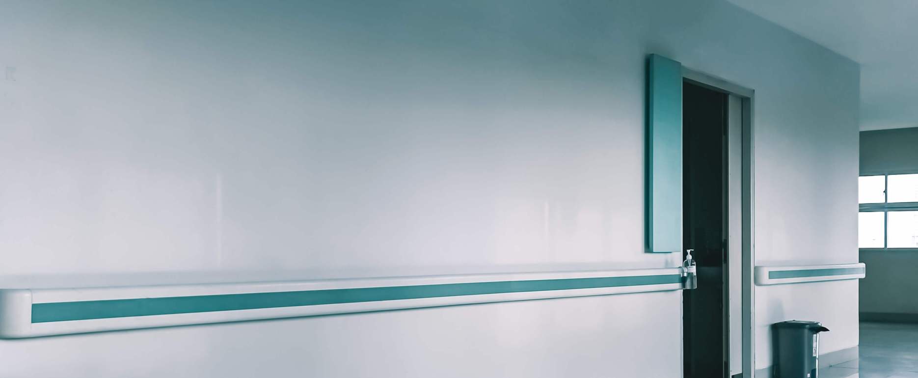 Empty,Hospital,Hallway,With,Handrails,,A,Doorway,,And,A,Trash