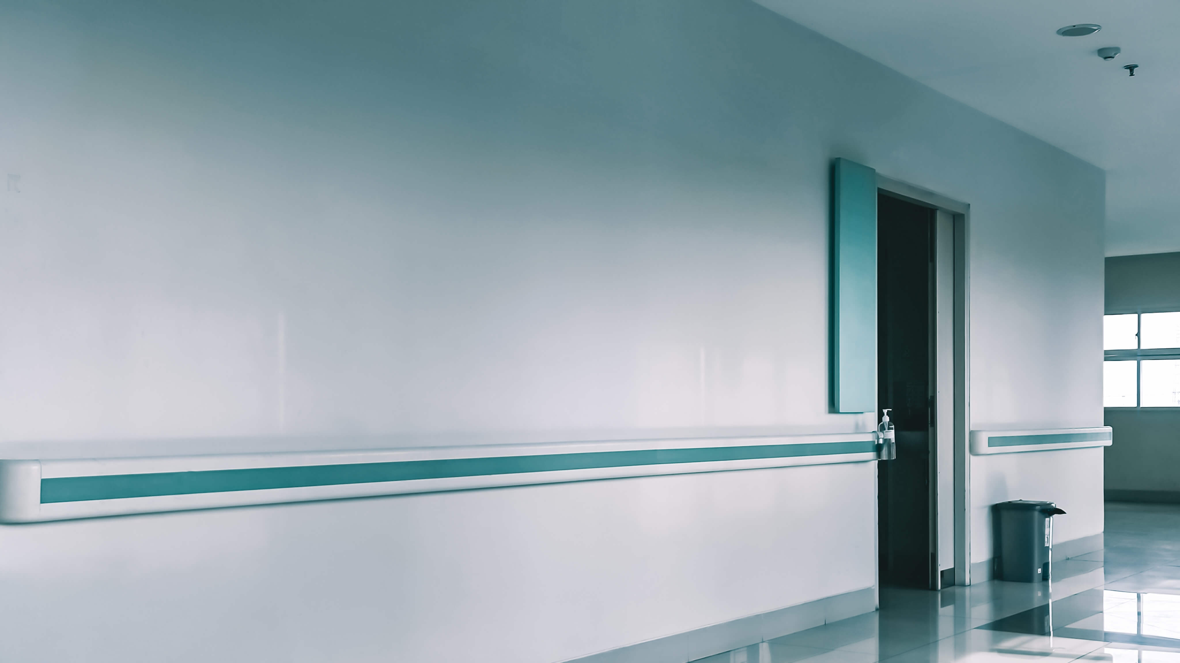 Empty,Hospital,Hallway,With,Handrails,,A,Doorway,,And,A,Trash