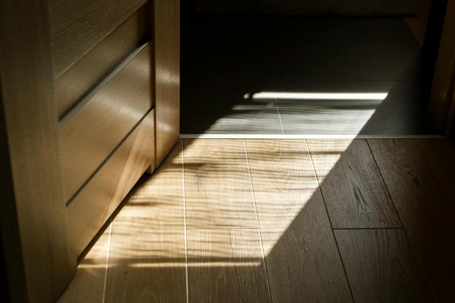a rectangular sunlight cast on parquet floor