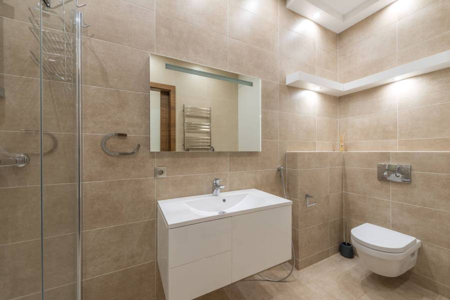 a white sink with mirror inside the bathroom