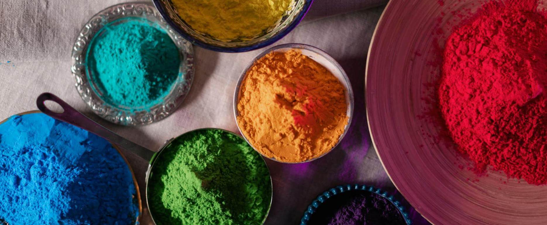top view of multicoloured powders in bowls and plates