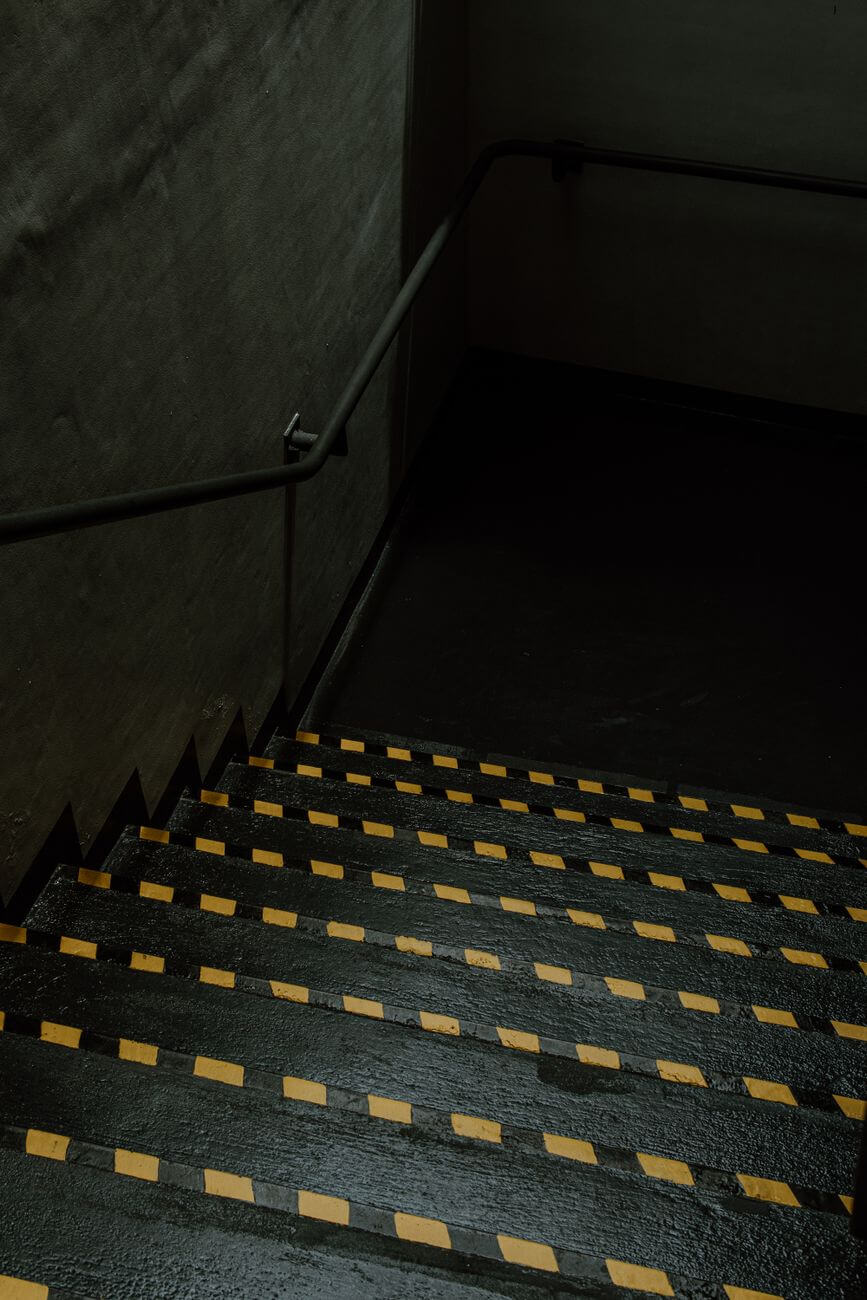 dimly lit industrial staircase with handrail