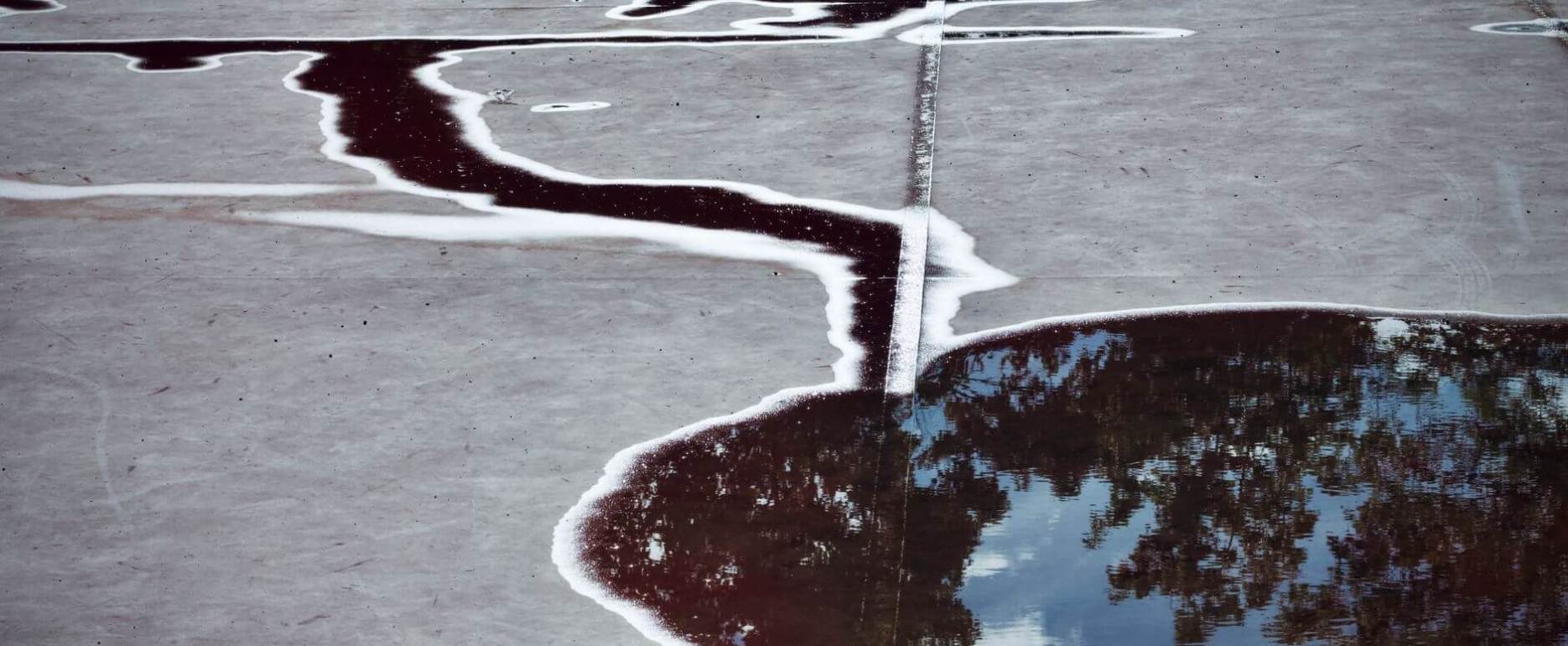 abstract reflection in a puddle on concrete surface
