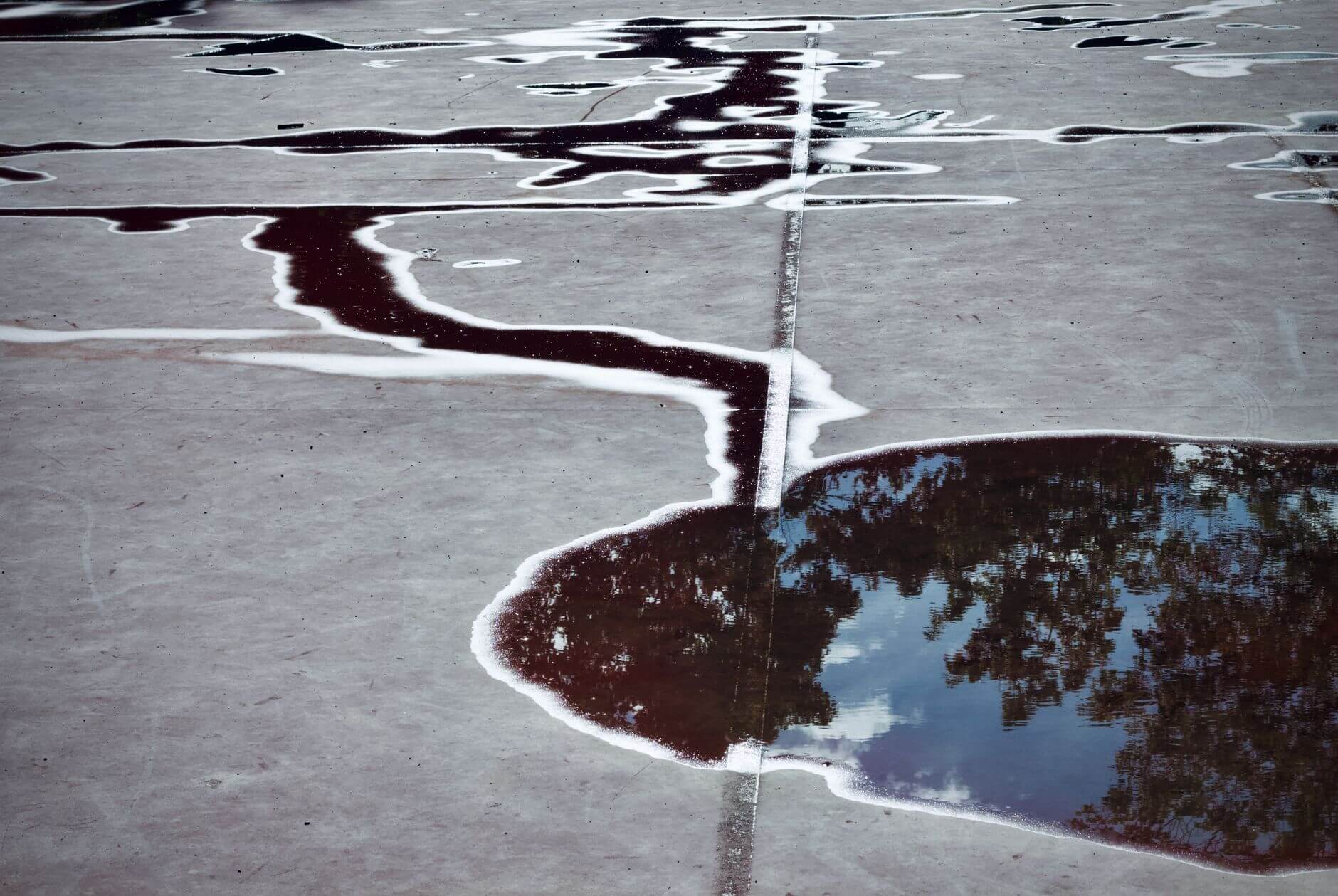 abstract reflection in a puddle on concrete surface