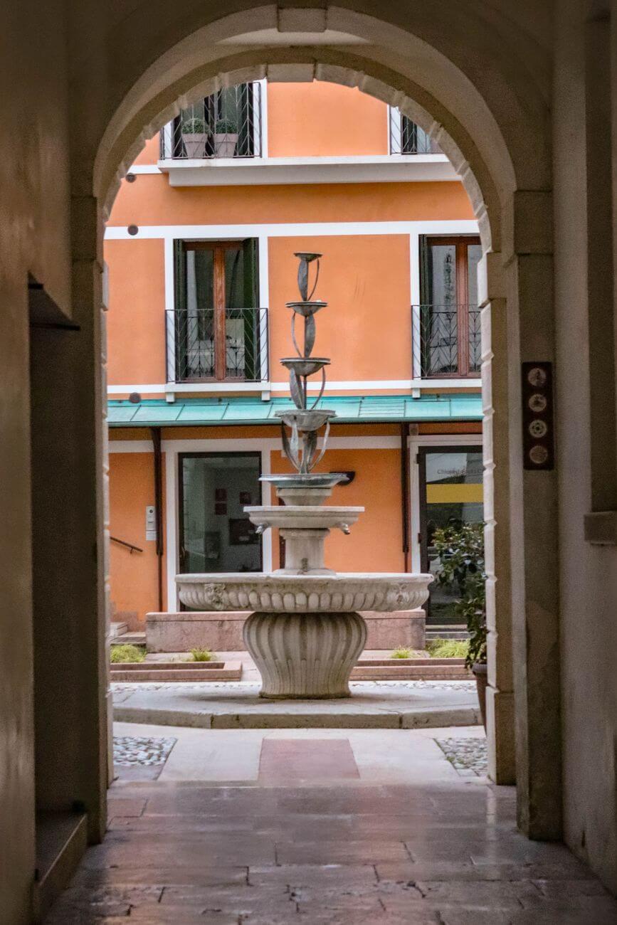 elegant fountain through stone archway